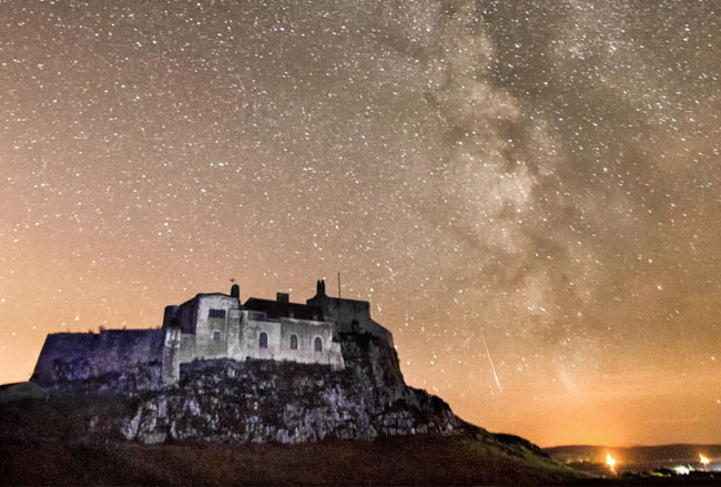 PIC BY Alec Jones/Geoff Robinson Photography 07976 880732. Picture shows the Perseid Meteors shower by the Holy Island of Lindisfarne,Northumberland on August 9th 2016. The Perseid meteor shower takes place each year through July and August and is the result of particles falling from the Comet Swift-Tuttle, which orbits the sun every 133 years and was first seen in 1862. The trail of particles forms meteors, or shooting stars as they are also known, which heat up as they enter the Earth¿s atmosphere creating tails of light across the sky. These specific meteors travel at a speed of 132,000 miles per hour and are called Perseids due to the way in which they appear to streak away from the Perseus Constellation